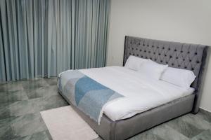 a bedroom with a bed with a silver headboard at La Petite Résidence- Private in Kigali