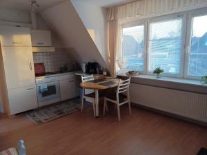 a kitchen with a table and chairs in a room at Ferienwohnung Dau II in Nübbel