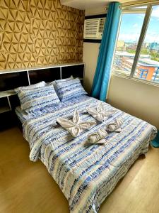 イロイロにあるWonderful One Bedroom at Avida 40の窓付きのベッド