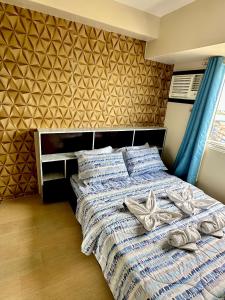 イロイロにあるWonderful One Bedroom at Avida 40のタオルが敷かれたベッドのある寝室