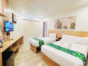 a hotel room with two beds and a television at Summer in Lapu Lapu City