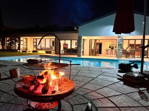 SandtonLuxurious, spacious & central的夜间游泳池前的火坑