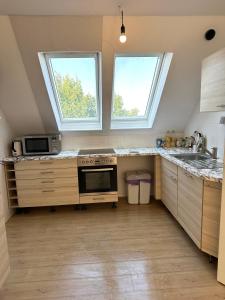eine Küche mit einem Herd und 2 Fenstern in der Unterkunft Großes 2-Zimmer Apartment mit TV, Wifi in Oerlinghausen