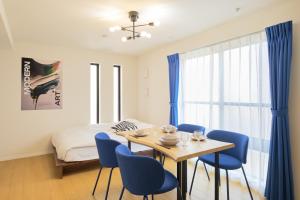a bedroom with a bed and a table and chairs at Ruygo Setagaya in Tokyo