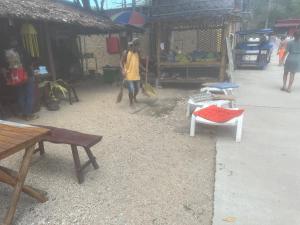 a man standing in a market with a broom at Binhs Rolls in Ko Lanta