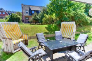 a patio with two chairs and a table and a table and chairs at Windeby 1T in Wenningstedt