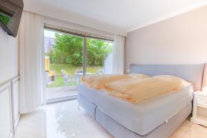 a bedroom with a bed and a large window at Windeby 1T in Wenningstedt