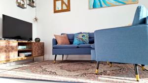 a living room with a blue couch and a tv at BlueCharme modern apartment in Quartu SantʼElena