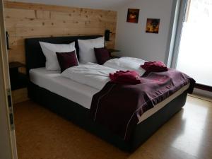 a large bed with two red roses on it at Alpenzauber Ofterschwang in Ofterschwang