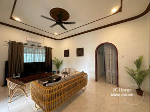 a living room with a couch and a ceiling fan at Kempas Kampung style 12pax Family Suites in Johor Bahru
