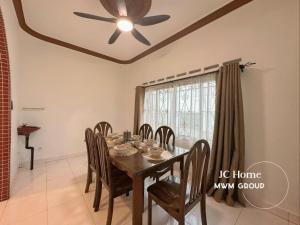 a dining room with a table and a ceiling fan at Kempas Kampung style 12pax Family Suites in Johor Bahru