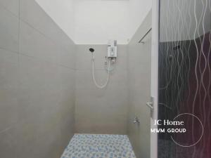 a bathroom with a shower with a toilet in it at Kempas Kampung style 12pax Family Suites in Johor Bahru +19 photos