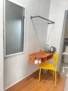 a bathroom with a desk and a yellow chair at 2N Residence in Siem Reap