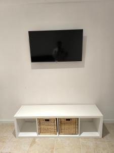 a white table with a television on a wall at Appartement avec une chambre et tout équipé dans centre ville in Montélimar