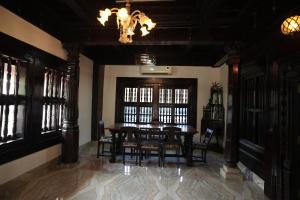ein Esszimmer mit Tisch und Stühlen und einem Kronleuchter in der Unterkunft Heritage Villa in Mangaluru