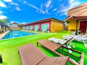 une cour avec une piscine et une pelouse avec des chaises dans l'établissement Lanta For Rest Boutique, à Ko Lanta