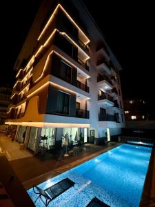 ein Gebäude mit Schwimmbad bei Nacht in der Unterkunft Apartmen in Alanya in the city center by the sea in Alanya