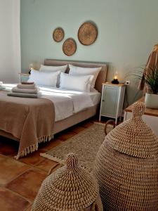 a bedroom with a bed and two baskets on the wall at Pelekanos Apartment in Kamilari