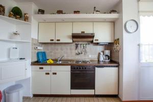 a kitchen with white cabinets and a black oven at FeWo Krüger 19 in Dahme