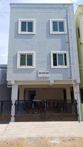 a white building with a sign that reads writers inn at WHITRS INN KILAMBAKKAm in Chennai +21 photos