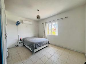 佩雷贝勒Azur Beach Complex - 1 min from Pereybere beach的带床和窗户的卧室