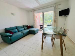 佩雷贝勒Azur Beach Complex - 1 min from Pereybere beach的客厅里有一张蓝色沙发和一张玻璃桌 更多2张照片