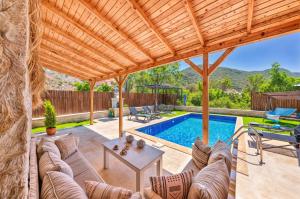 patio con divano, tavolo e piscina di Villa Samas - Doğanın Kalbine Küçük Bir Kaçamak 2 Plus 1 a Kaş