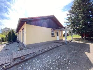 a small yellow house with a roof at Trudi in Funfseen +7 photos