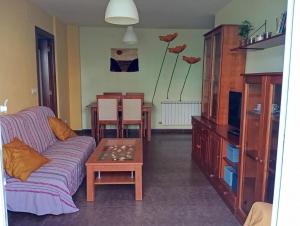 a living room with a couch and a table at Familiar bajo con jardín en Gibaja in Gibaja
