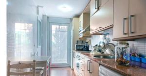 a kitchen with a sink and a counter top at Familiar bajo con jardín en Gibaja in Gibaja