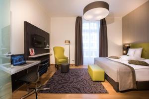 ein Hotelzimmer mit einem Bett, einem Schreibtisch und einem Computer in der Unterkunft Collegium Leoninum in Bonn