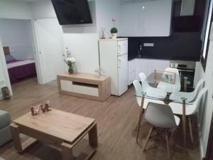 a living room with a table and chairs and a kitchen at Apartamento Casa Vega in Bueu