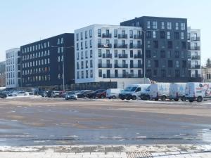 a parking lot with cars parked in front of a building at Ozo Parko Butas in Vilnius