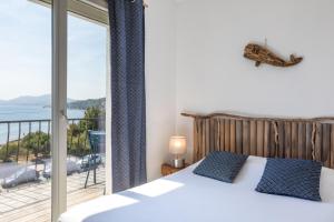 a bedroom with a bed and a view of the ocean at Hôtel Almanarre Plage - Hôtel Eco-Responsable face à la mer in Hyères