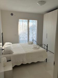 een witte slaapkamer met een groot bed en een raam bij Casa vacanze Sofy & Marty in Cattolica