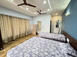a bedroom with two beds and a ceiling fan at Suites by the Glasswater homestay in Kalyānpur