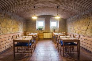 a room with wooden tables and chairs in a stone wall at Hotel Lions Plzen in Pilsen