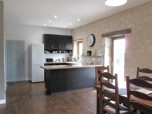 Il comprend une cuisine équipée d'un réfrigérateur blanc, d'une table et de chaises. dans l'établissement La Bergerie, à Pessac-sur-Dordogne