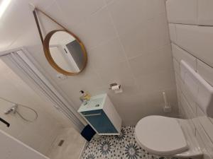 a bathroom with a white toilet and a mirror at La Casita de Ana in Águilas +14 photos