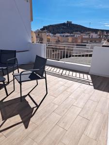 a balcony with chairs and a view of a city at La Casita de Ana in Águilas