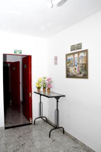 Habitación con mesa y puerta roja en Hotel Cco Goiânia en Goiânia