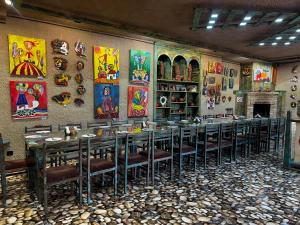 a dining room with tables and chairs and paintings on the wall at Machanents Art Hotel in Vagharshapat +23 photos