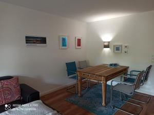 Una sala de estar con una mesa y sillas de madera. en Galerie Storm, en Haby