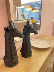 two black animal heads on a table in front of a mirror at Apartamentos Minica Home Rosé in Logroño