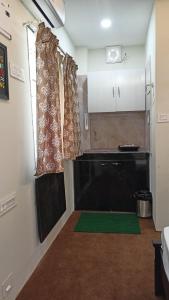 シリグリにあるcozy comfort homestayのキッチン(黒いカウンター、緑の敷物付)