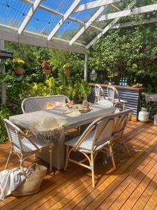 Un patio con una mesa y sillas en una terraza. en Balcombe Retreat, Family Escape with Sea Views, en Mornington