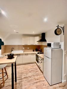 a kitchen with a white refrigerator and a table at Seven Keys - Enclave du Coiron in Saint-Vincent-de-Barrès +6 photos