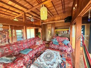 a living room with a red couch and a rug at -1日1組限定一棟貸し-坂嶺ふる里庵-大人数におすすめ- in Nishime