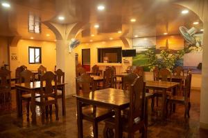 a restaurant with wooden tables and chairs in a room at Batanes Seaside Lodge & Restaurant in Basco
