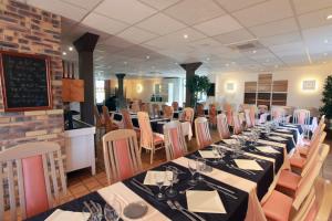 a dining room with long tables and chairs at Hotel Le Relais des Champs in Eugénie-les-Bains